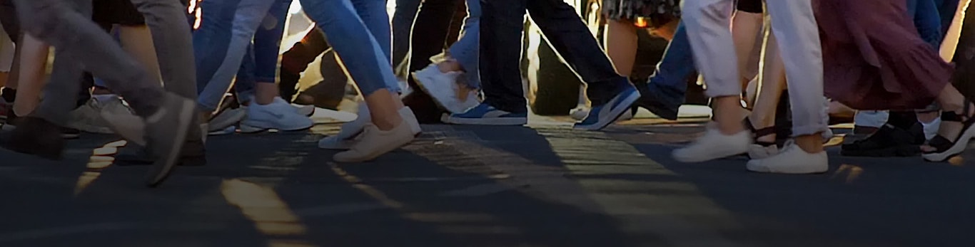 Pešački prelaz u gradu pokazuje desetine ljudi koji hodaju u različitom smeru dok prelaze ulicu