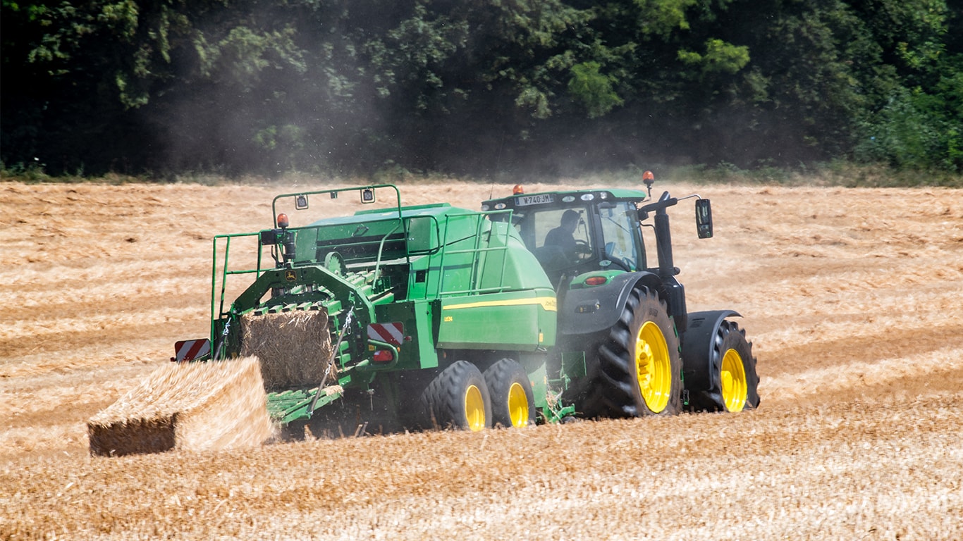 John Deere L634 velika balirka za bale četvrtastog oblika sa 6R traktorom u slami