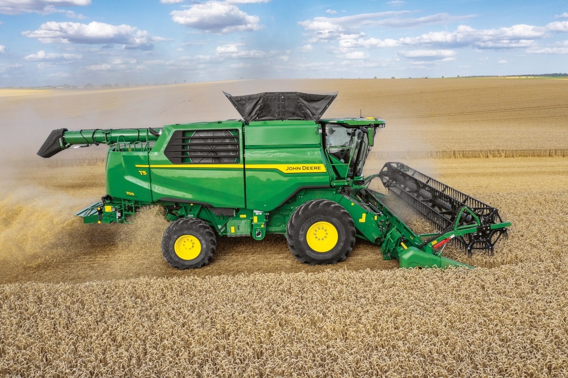 Bočni pogled na John Deere kombajn sa hederom za žetvu pšenice na velikoj njivi