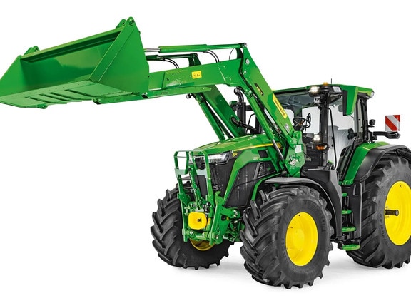 John Deere traktor sa spuštenim prednjim utovarivačem i pričvršćenom kašikom, izolovan na beloj pozadini.