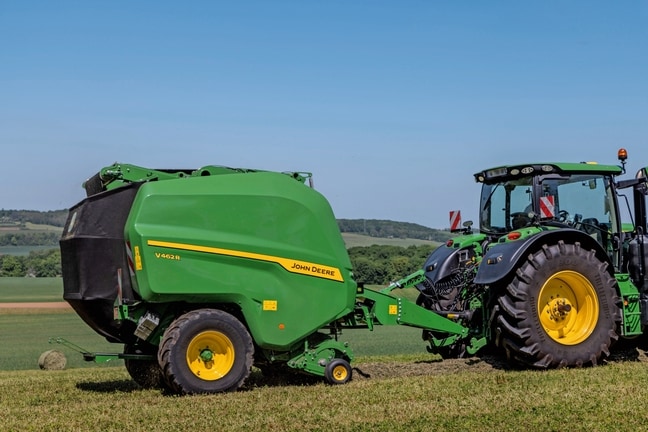 John Deere V462R koju vuče traktor John Deere 6R 185 balira seno